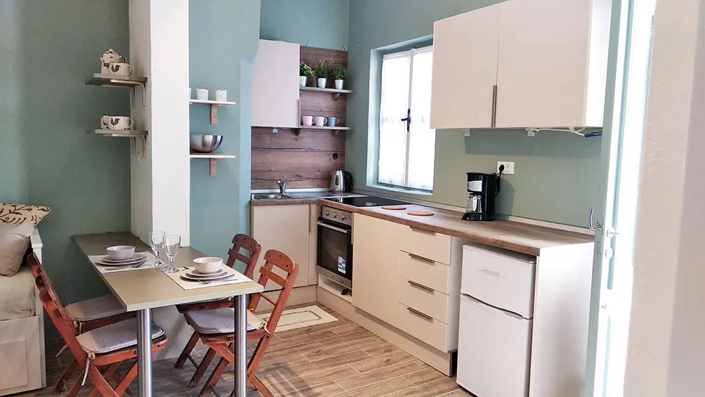 <p>Our kitchen is located in the open area of the living room. Bright and comfortable, fully equipped with everything you need to prepare your meals, it is complemented by a table for 4 people.</p>